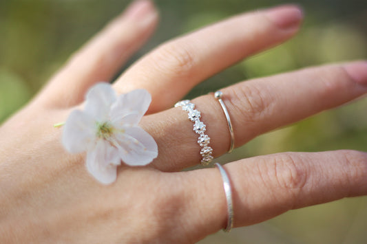 Daisy flower ring in sustainable sterling silver on finger. Handmade in New Jersey, US.