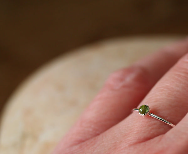 Peridot stacking ring on finger. Sterling silver. Handmade in the US with sustainable silver.