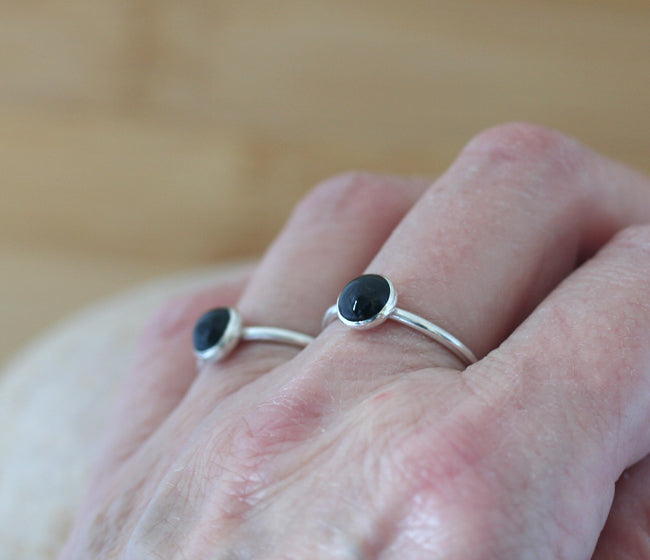 Black onyx stacking rings on fingers. Handmade in New Jersey with sustainable silver. Scandinavian design