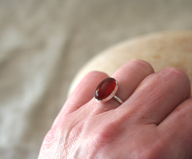 Oval classic carnelian ring handmade with sustainable silver in New Jersey. On finger. 