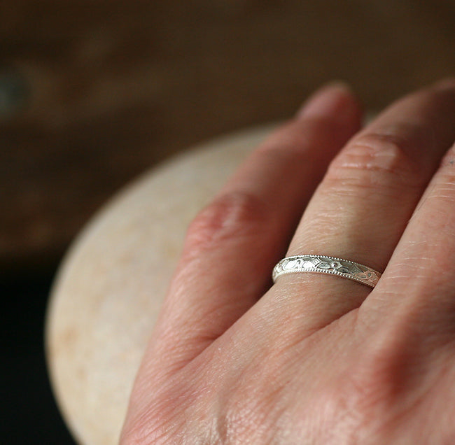 Floral stacking ring in sustainable sterling silver. On finger.