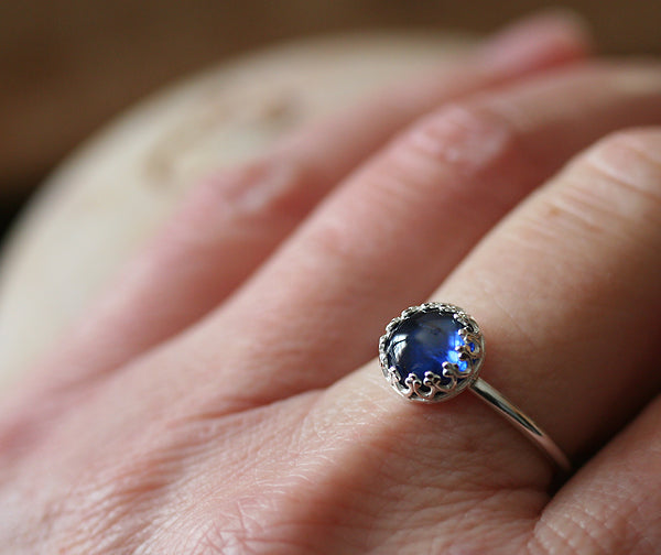 Ethical blue sapphire crown ring in sterling silver on finger. Handmade in the US.