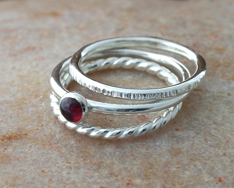 Garnet, twist, and tree bark stacking rings. Sterling silver. Handmade in the US with sustainable silver.