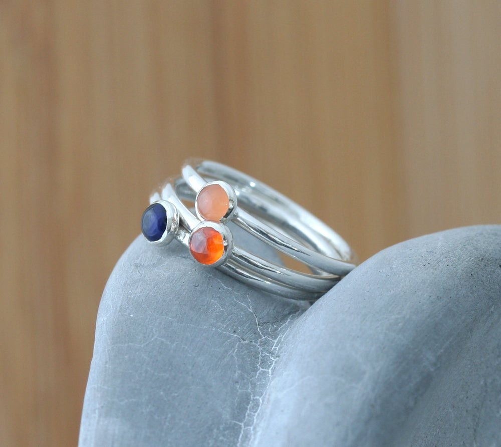 Orange cubic zirconia, peach moonstone, and blue sapphire stacking rings in all sizes. Ethical minimalist Scandinavian design. Handmade in New Jersey.