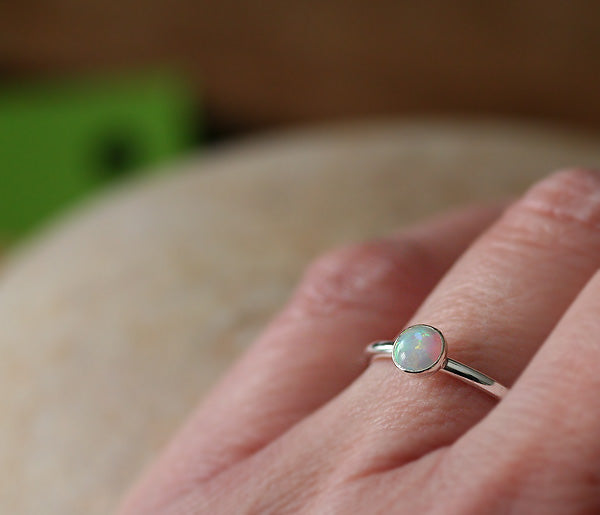 Small opal stacking ring on hand handmade in New Jersey, US. with ethical silver.