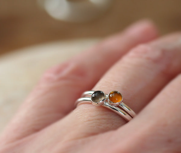 Citrine and smoky quartz stacking rings on finger. Sterling silver. Handmade in the US with sustainable silver.