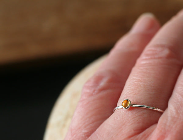 Thin citrine stacking ring on finger. Sterling silver. Handmade in the US with sustainable silver.